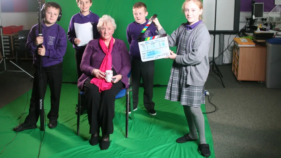 An older woman is interviewed by four children