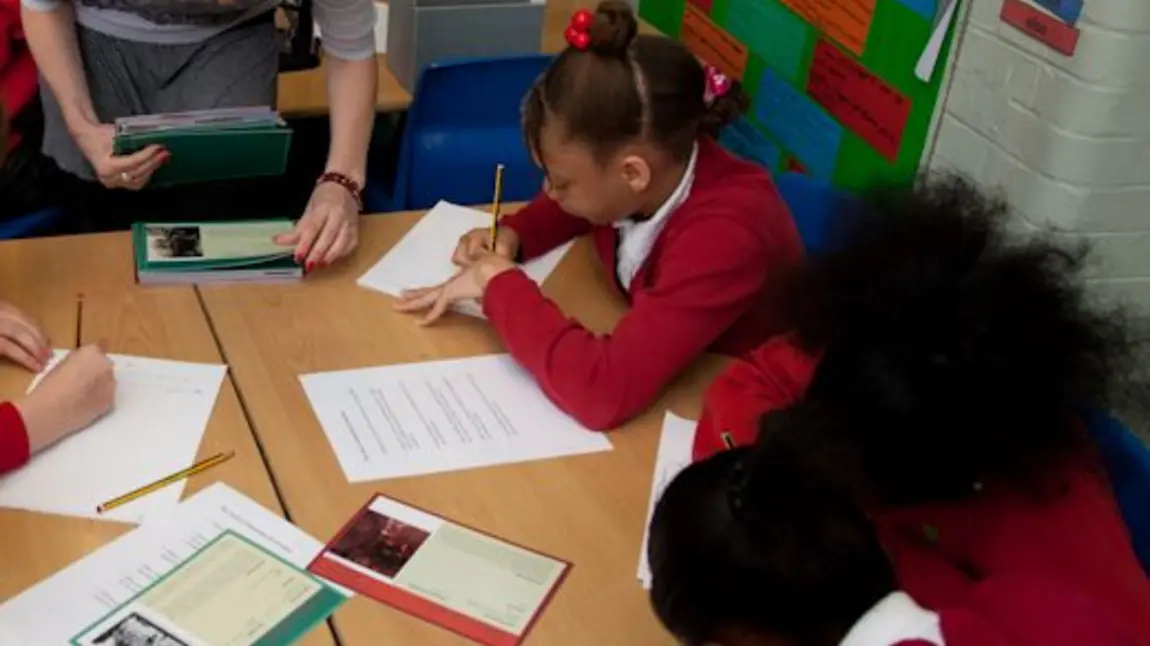 School children look at First World War sources in a classroom