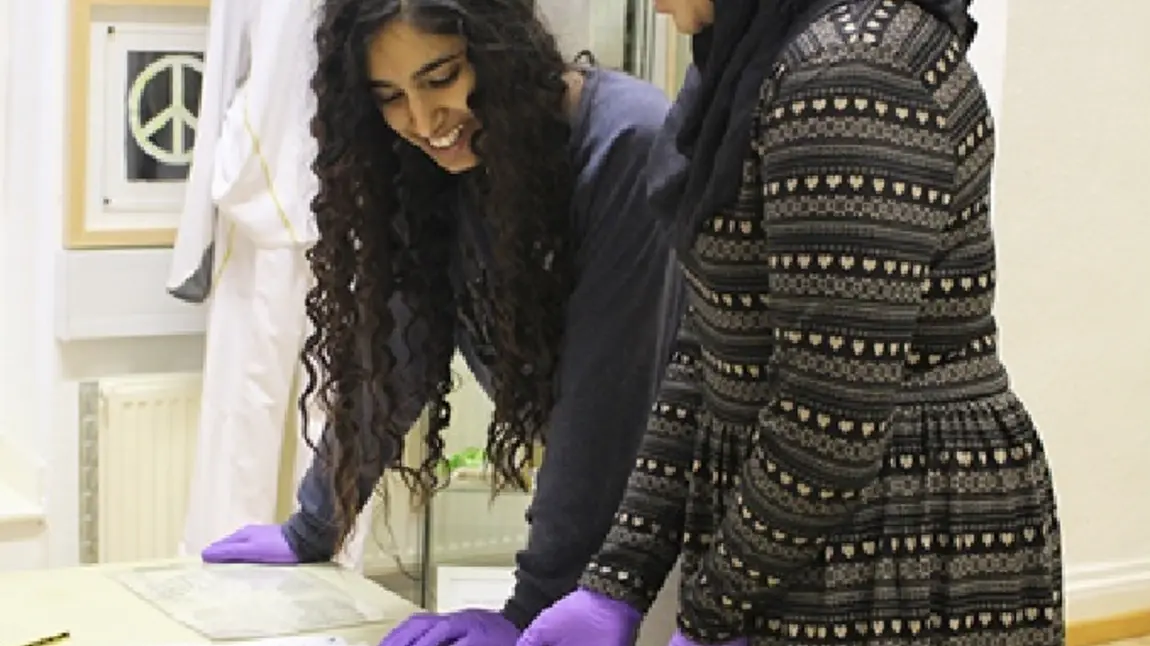 Hanna Ahmed (left) and Nazish Majid looking at items from the archive at The Peace Museum, Bradford