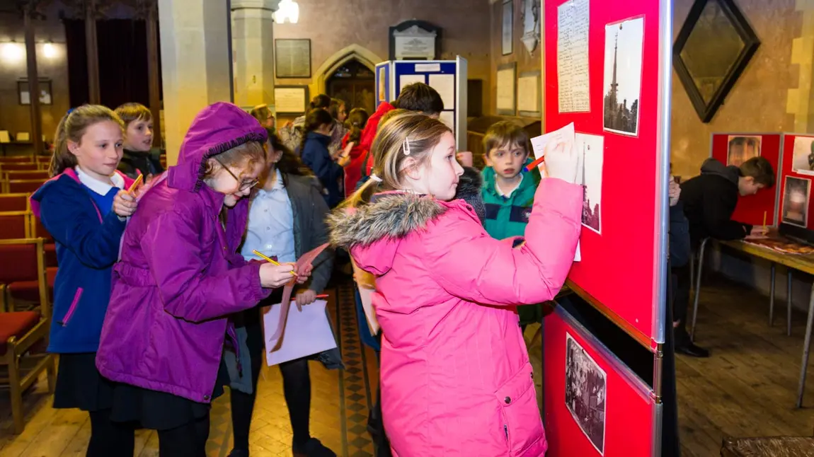 A group of school pupils make notes while taking part in a church trail