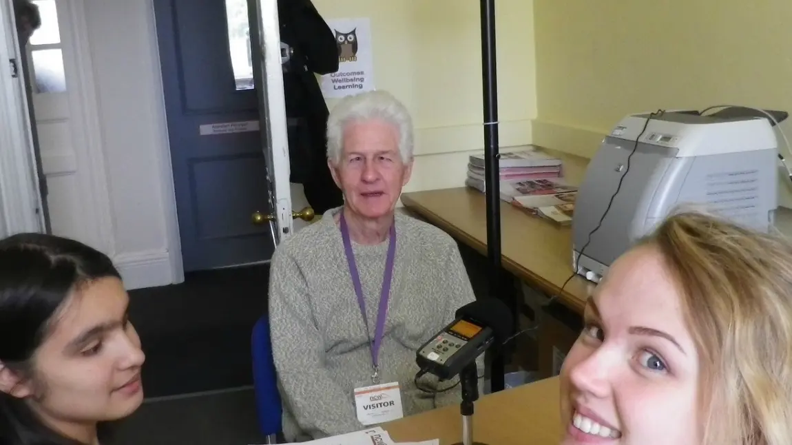 Two students interviewing an older person