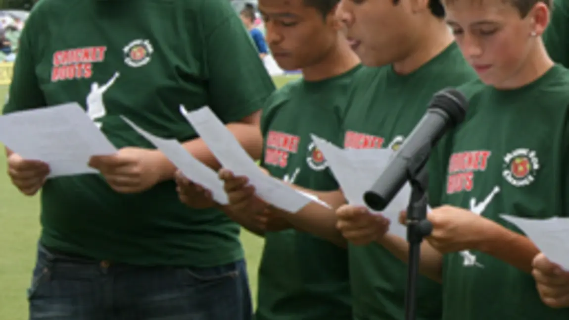 Young people performing a song at a cricket match