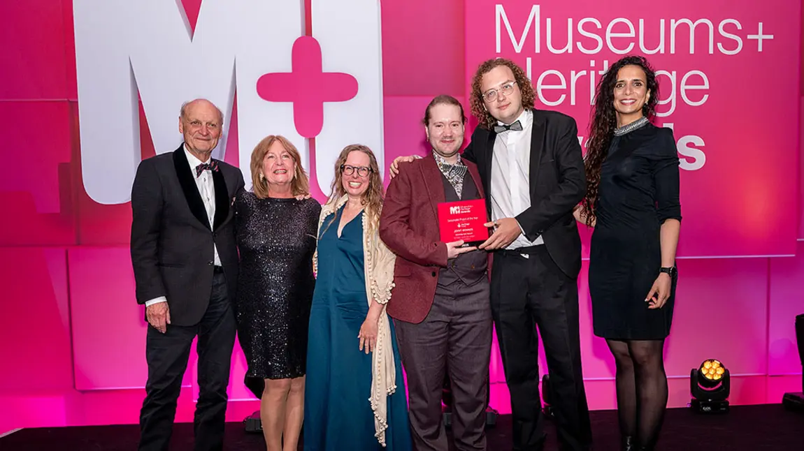 A group of people posing with an award