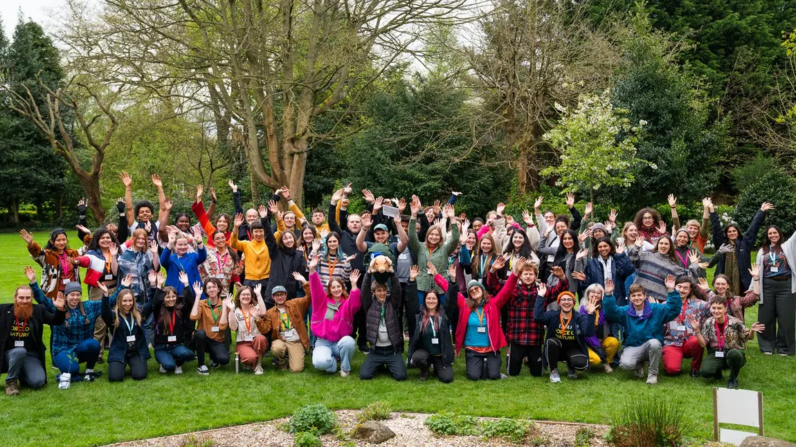A large group of young people cheering outdoors