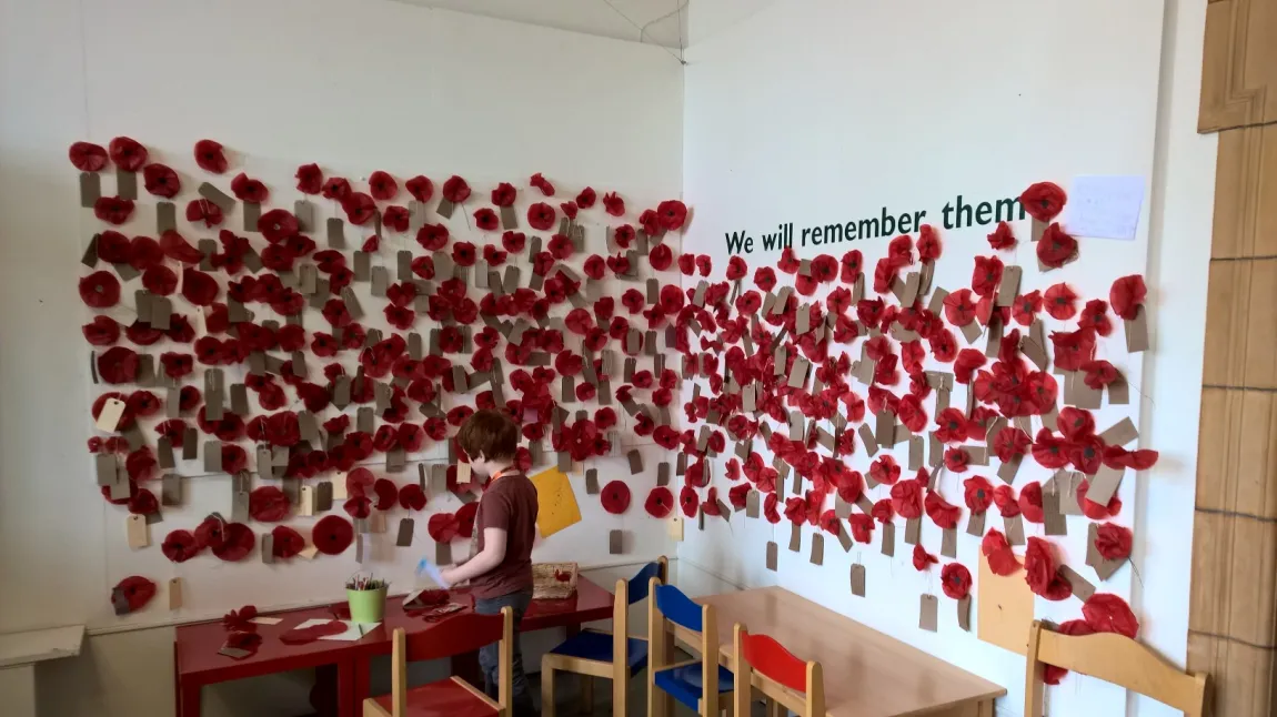 A young museum visitor adds to the poppy wall of remembrance at Worcester City Art Gallery and Museum