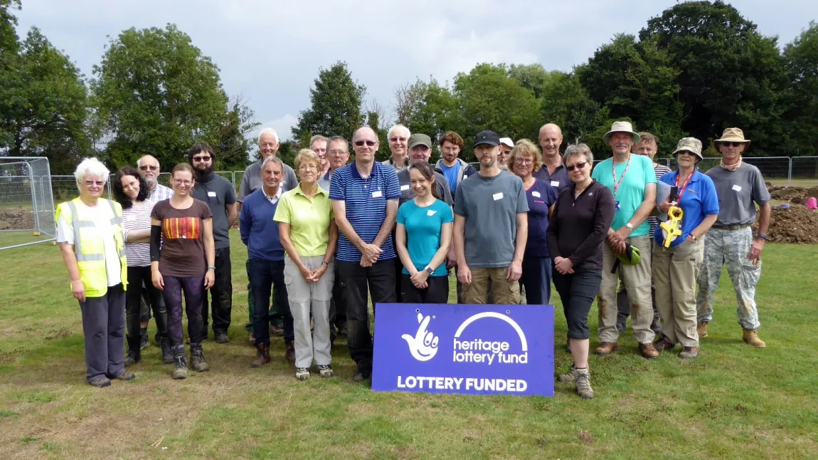 Project helpers next to a National Lottery funded sign