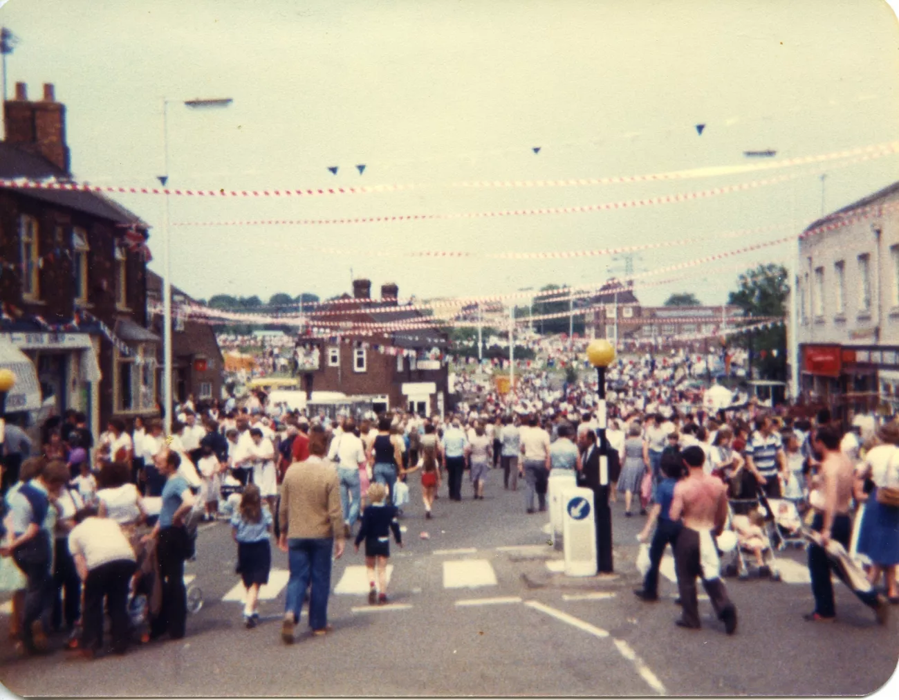 A dated image from 1982, with a Corby town square full of people and bunting overhead