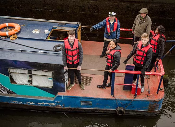 Young people on a boat on a canal