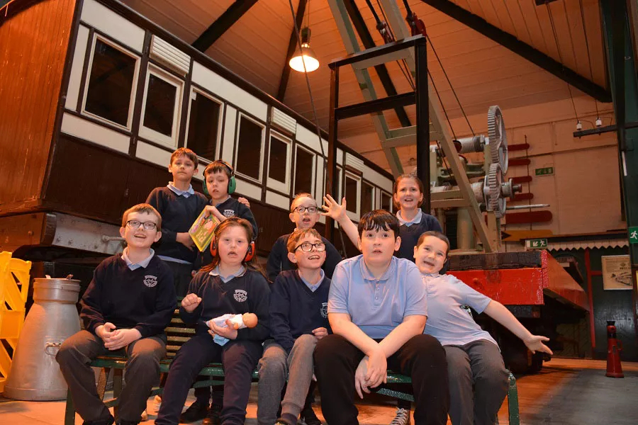 A group of school children taking a group photo at the museum